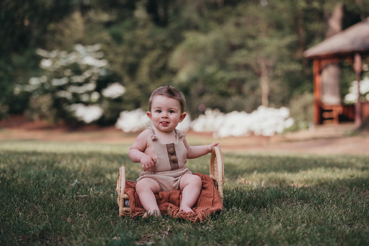 little boy sitting in a field