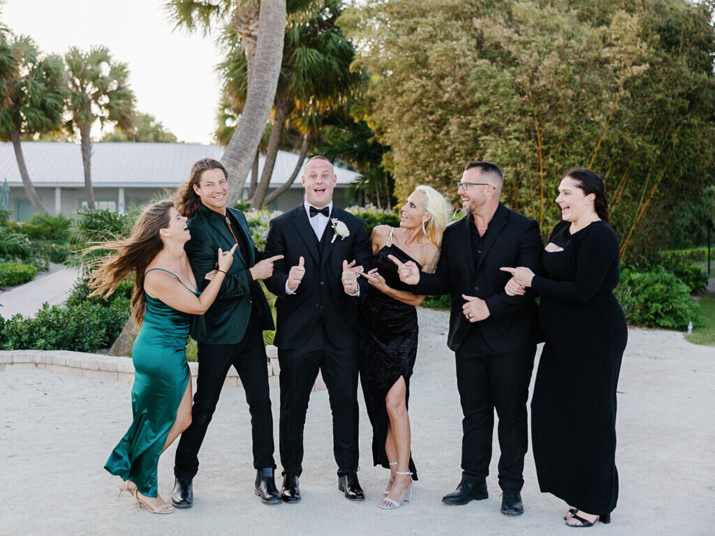 A joyful moment as the newlyweds celebrate with their wedding party, sharing laughter and excitement in a tropical garden setting. Captured by Claudia Amalia Photography, a Florida Keys wedding photographer specializing in destination wedding photography.