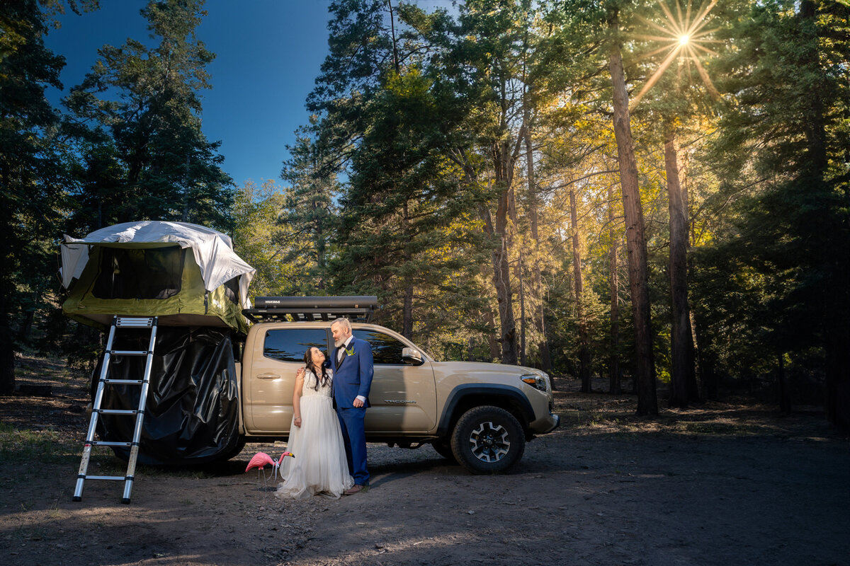 Bride and Groom eloping at Big Bear Buttercup Campground with Toyota rooftop camper truck during sunset.