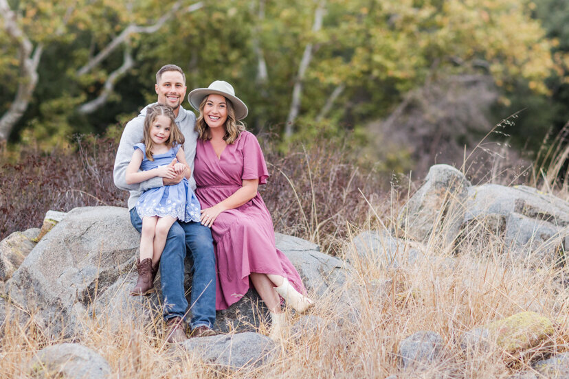 family-portrait-sititng-on-rock--sweetwater-river-bridge-san-diego