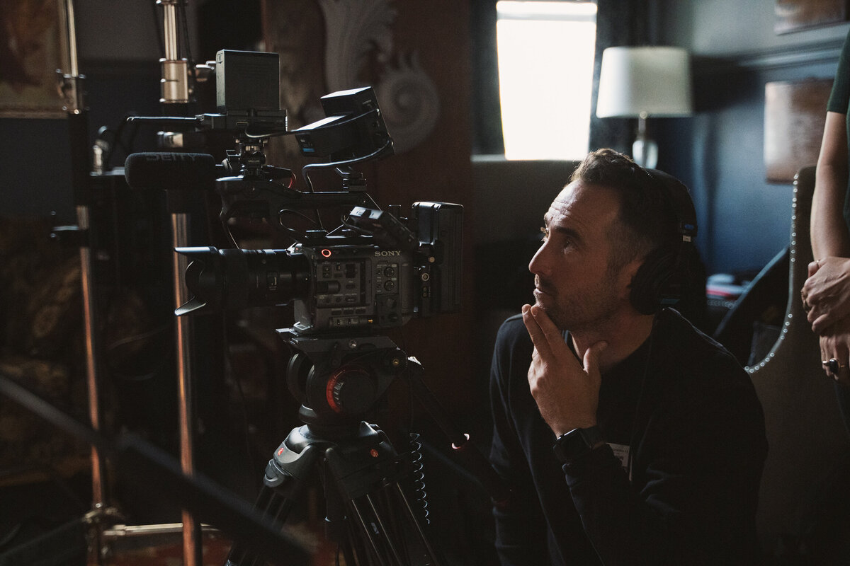 A videographer on set, carefully composing a shot with professional equipment. This image represents the meticulous process of creating high-quality promotional videos at Future Fox Media, Denver, Colorado.