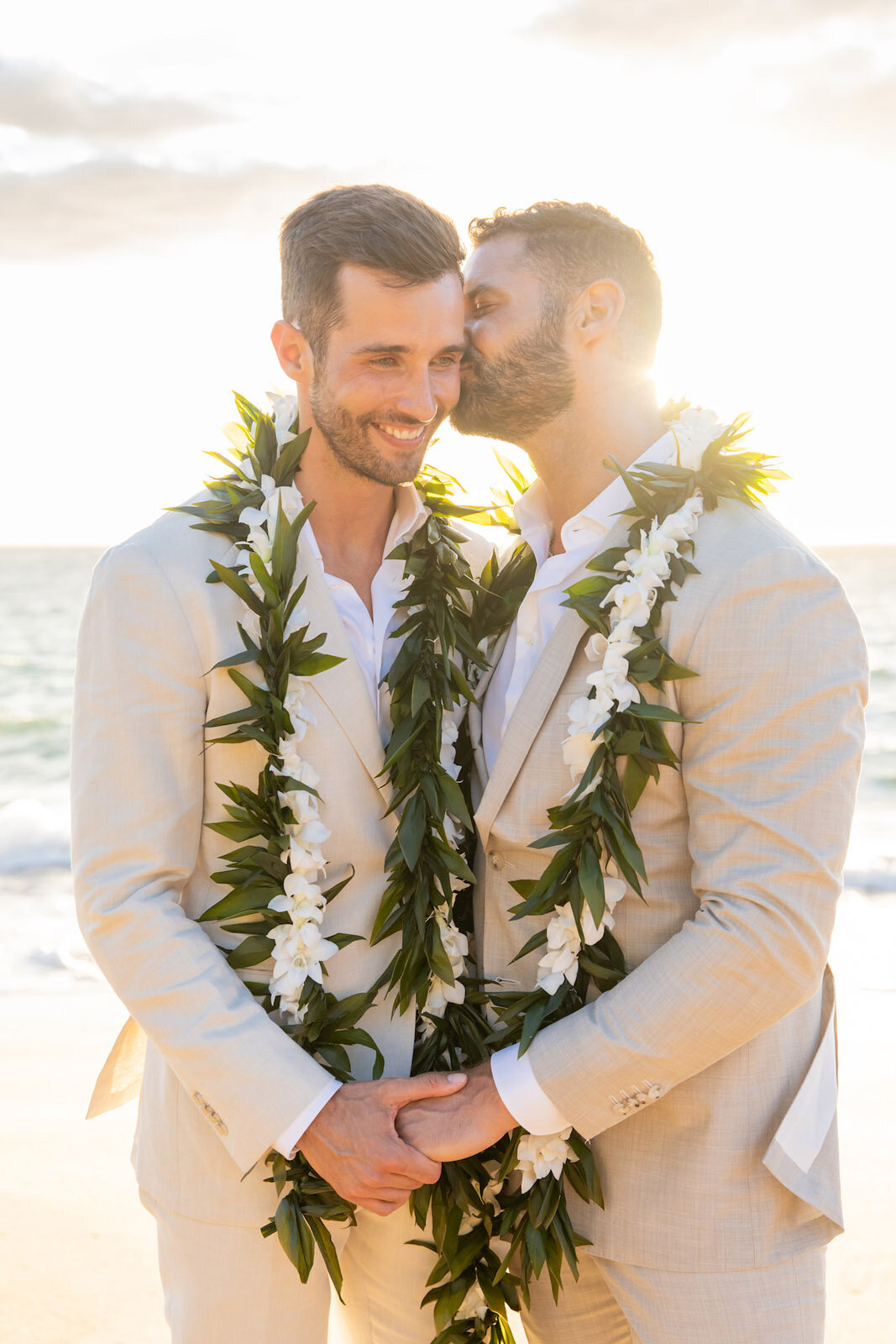 romantic maui wedding photo with two grooms dressed in tan suits