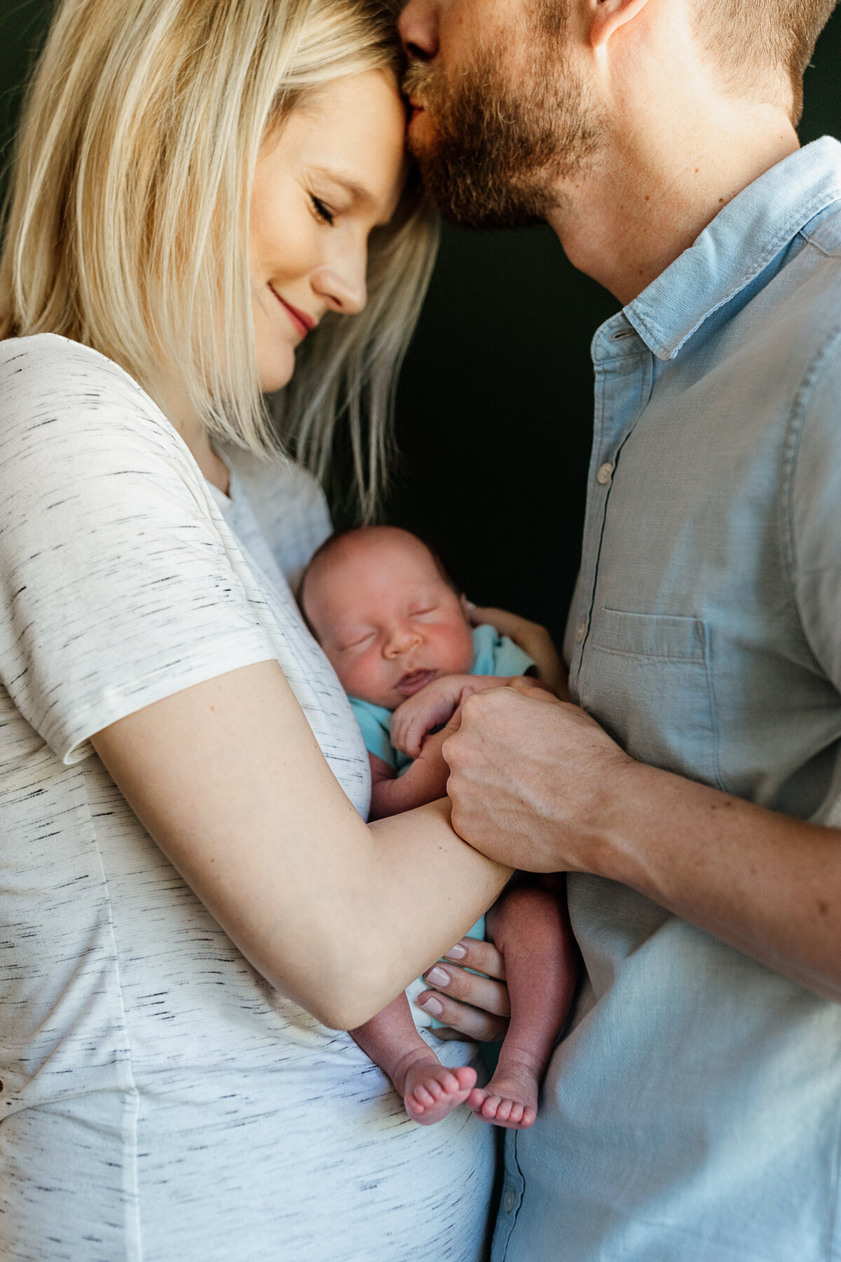 newborn with parents embracing