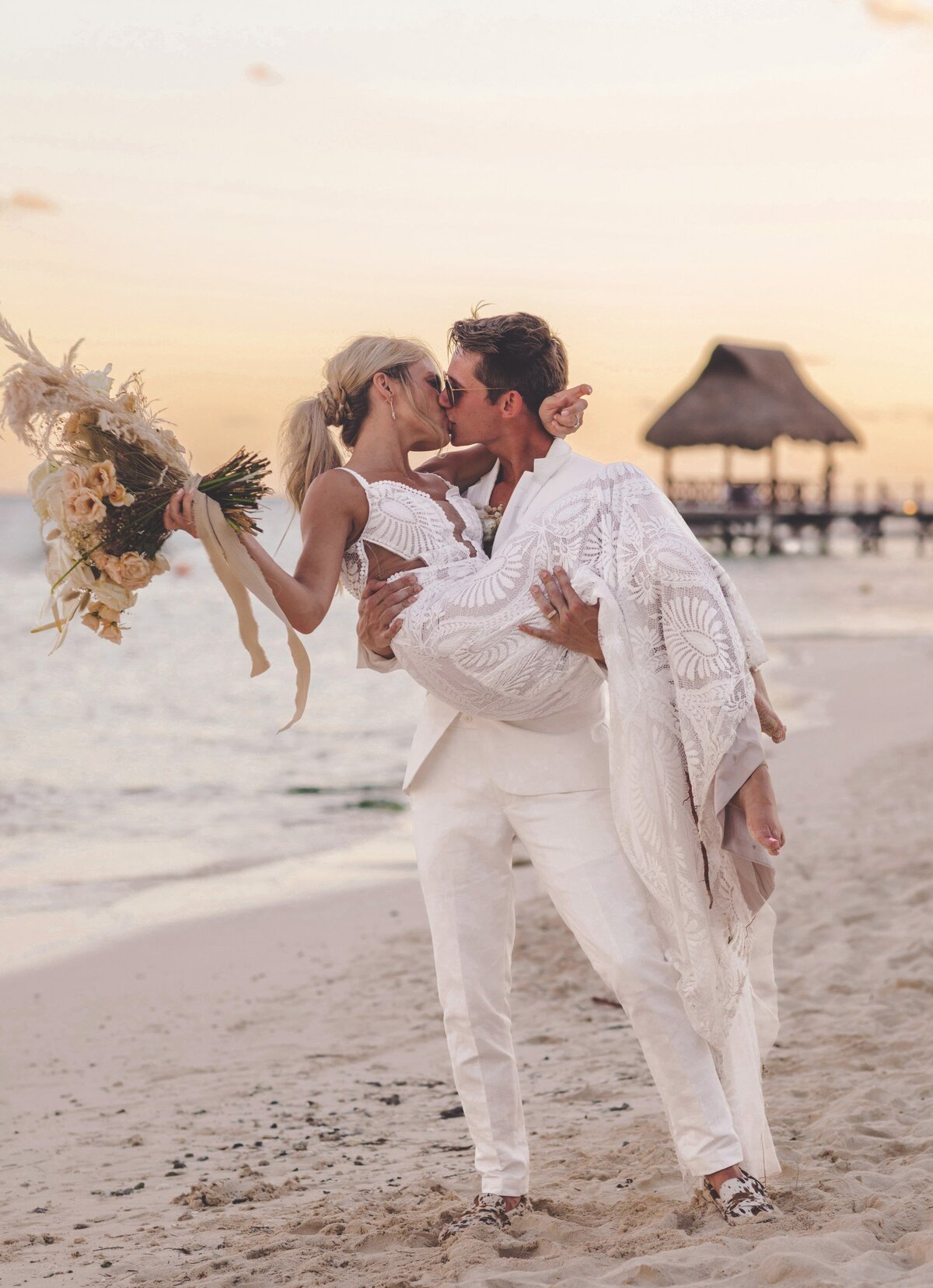 Bride and groom kissing on beach at viceroy riviera maya wedding