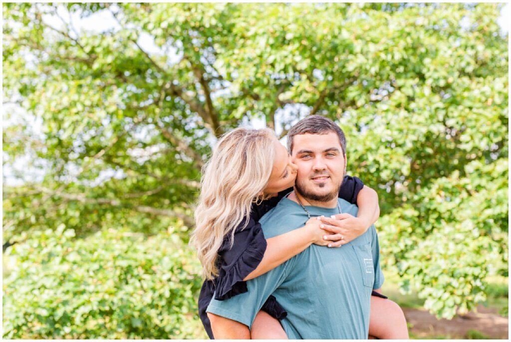 girl kissing guy on his back