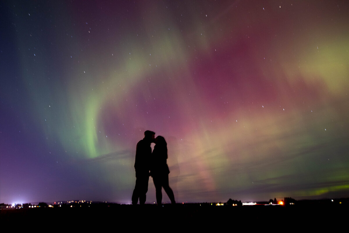 couple kissing under the aurora borealis