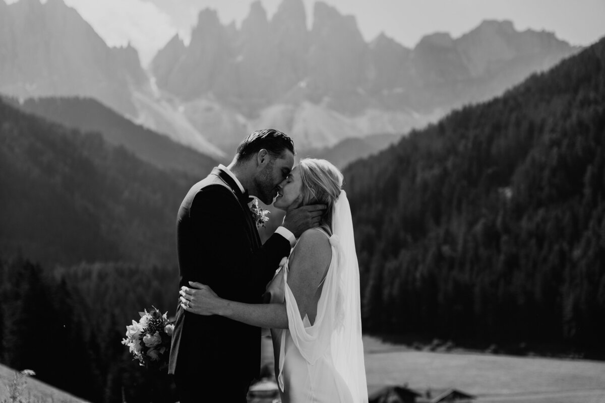 Couple kissing with Dolomites peaks in background
