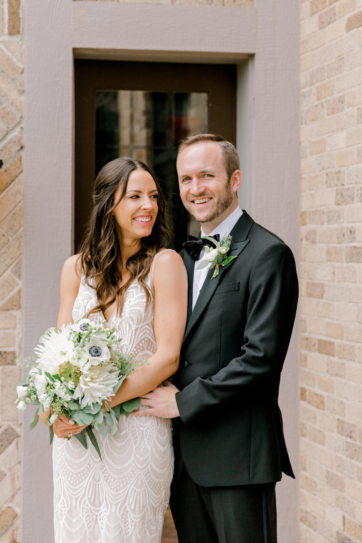 groom standing next to bride and smiling