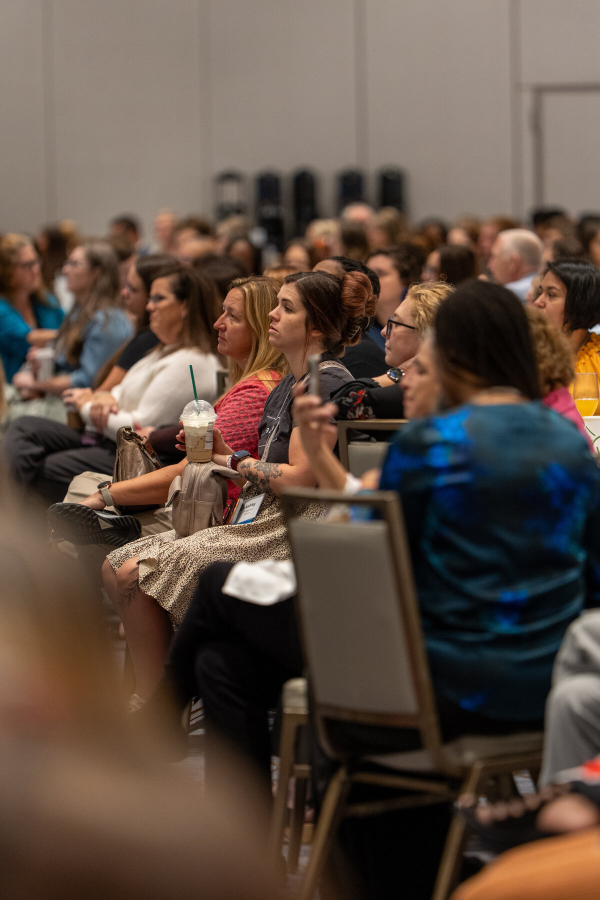 A group of people sitting at tables at a conference 