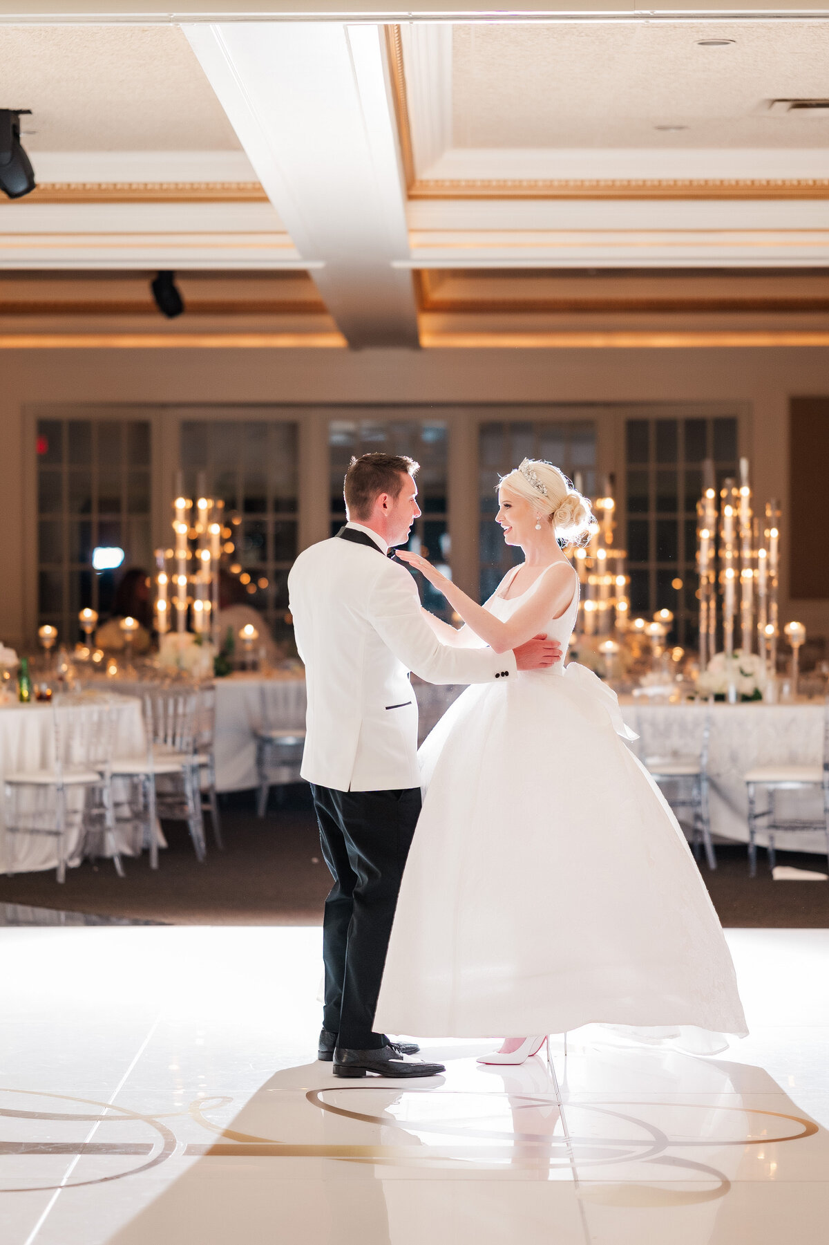 married couple having a private dance in the ballroom of The Grand Resort with candles and flowers and a custom white dance floor