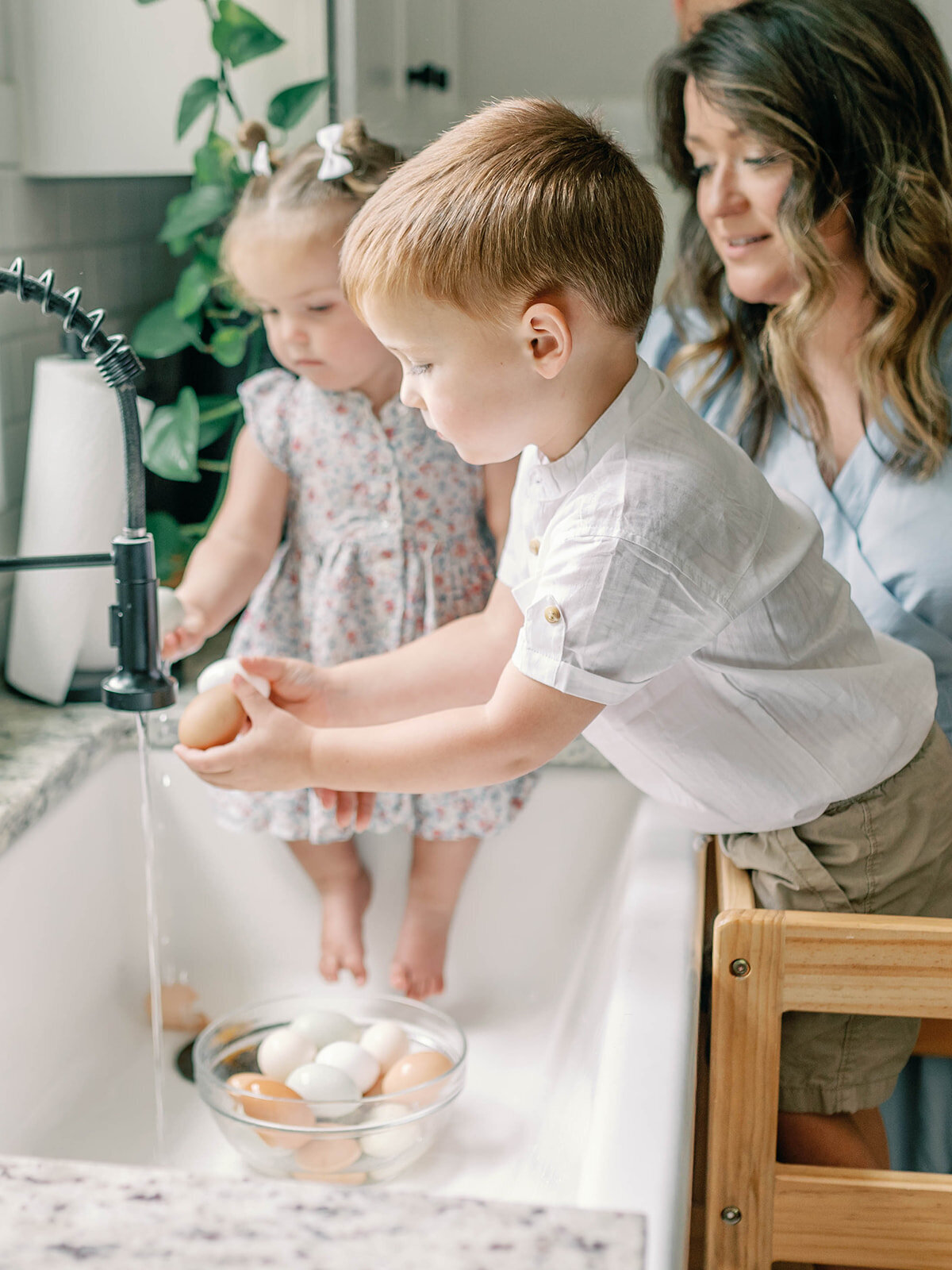 Brother and sister cleaning eggs in sink