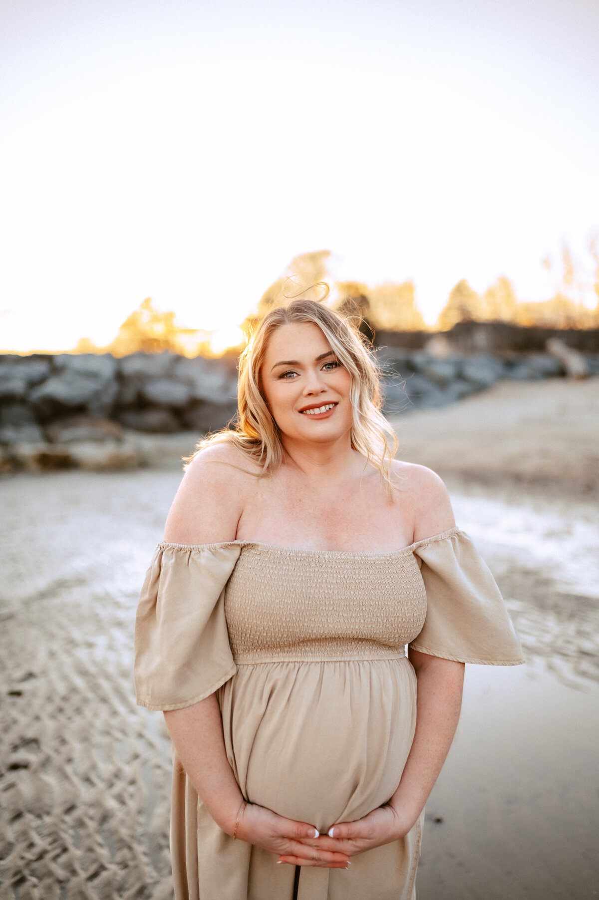 winter boho outdoor maternity session with blonde woman holding her belly