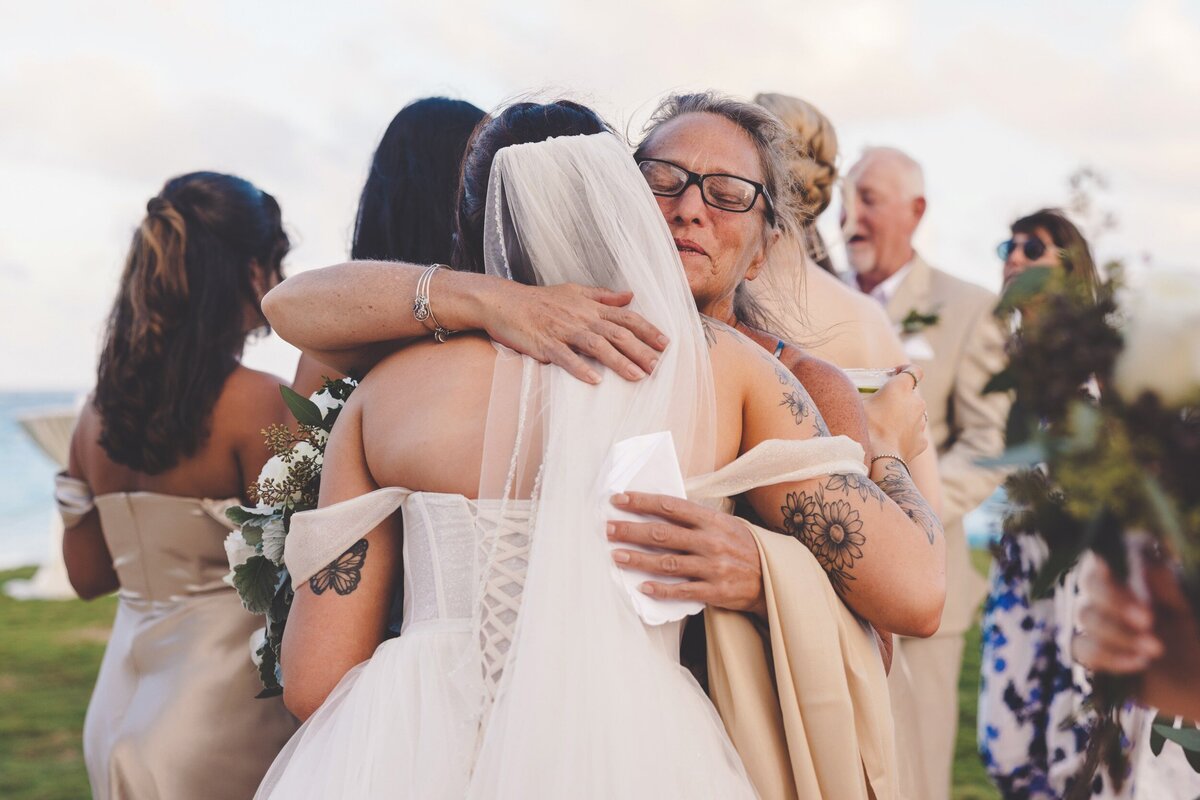Guest congratulating bride after wedding ceremony in Cancun with a hug.