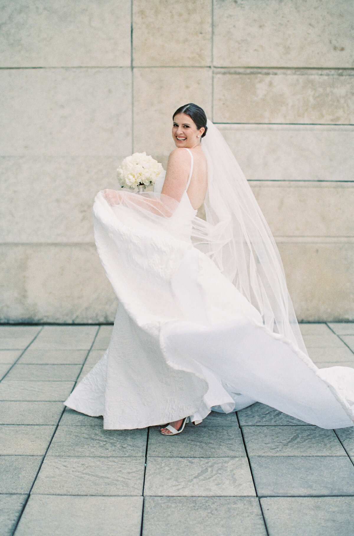 Bride joyfully twirls her veil at Saddle Country Club.