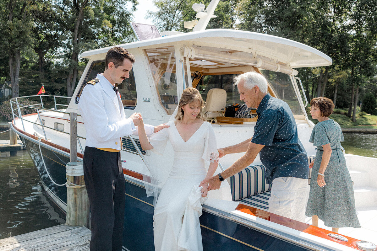 Man helping bride onto boat