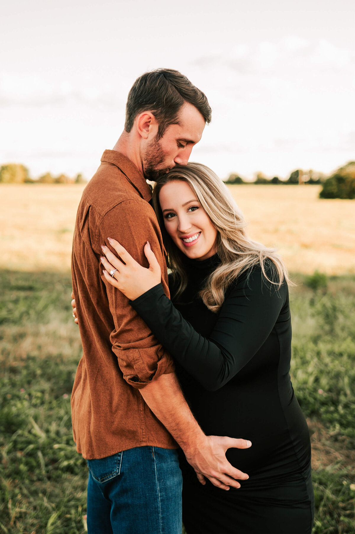 Springfield MO maternity photography of mom cuddling husband while he holder her baby bump