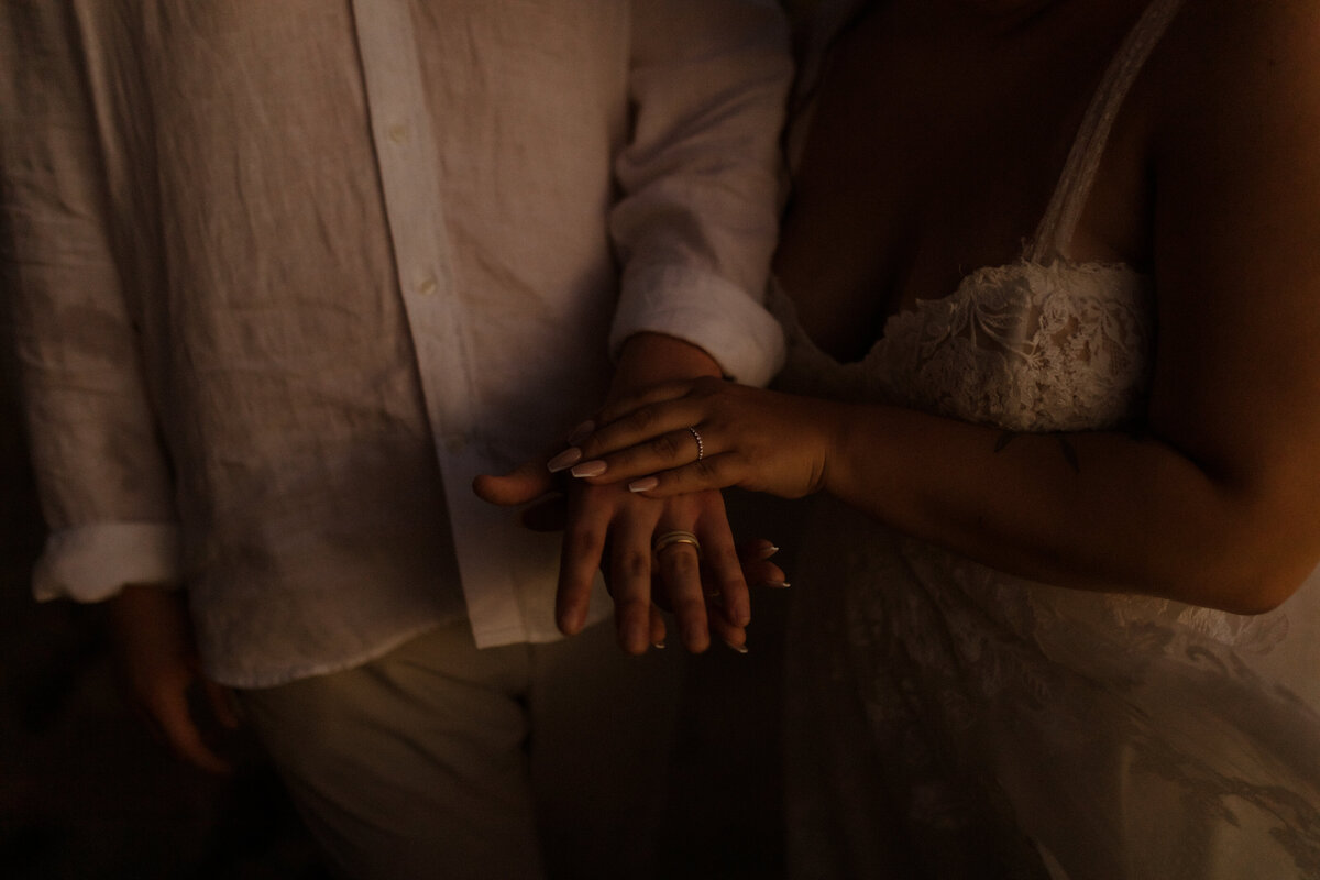 Bride and grooms hands at sunset