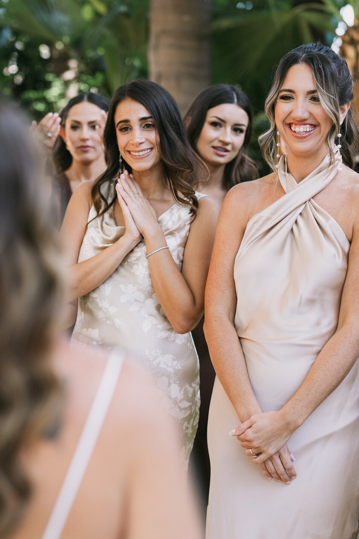 bridesmaids looking at the bride and expressing their emotions