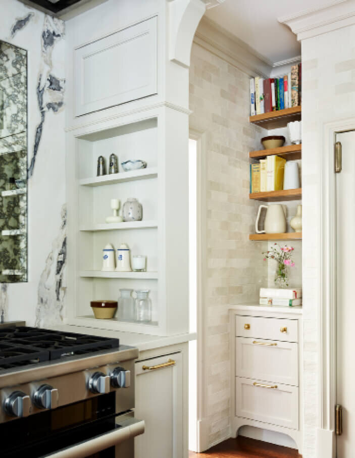 Interior decorators in Milton designed a custom hood for a kitchen remodel in Milton, Massachusetts, featuring white cabinets with natural oak accents.