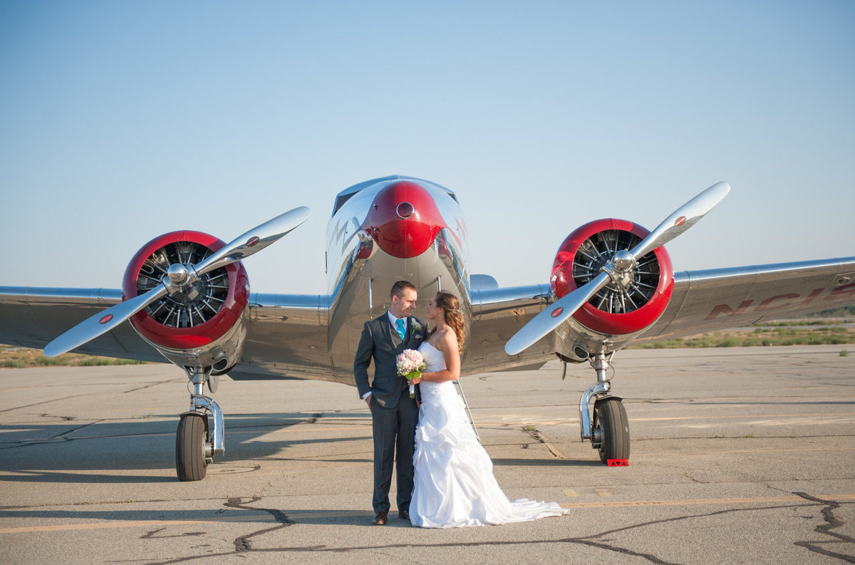 Chino Hills wedding photographer for the fun sweethearts. Bride and Groom portrait in airport hanger in Chino Hills. Airport wedding in Los Angeles by Faria Munmun.
