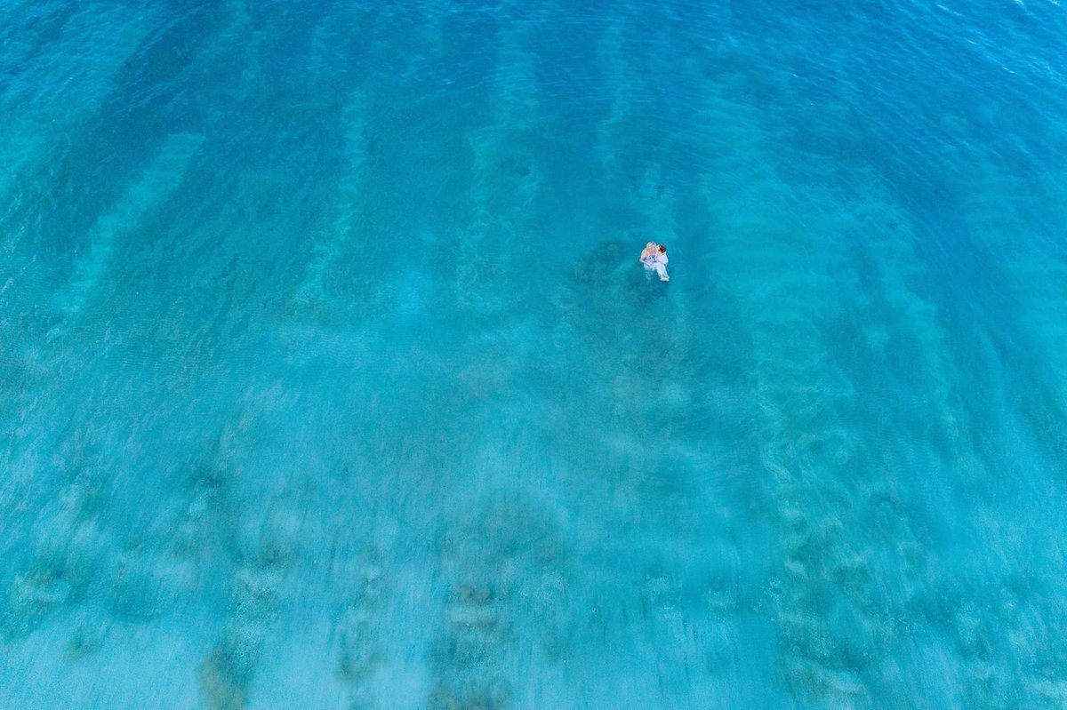 Maui drone proposal portraits featuring couple embracing in the turquoise ocean