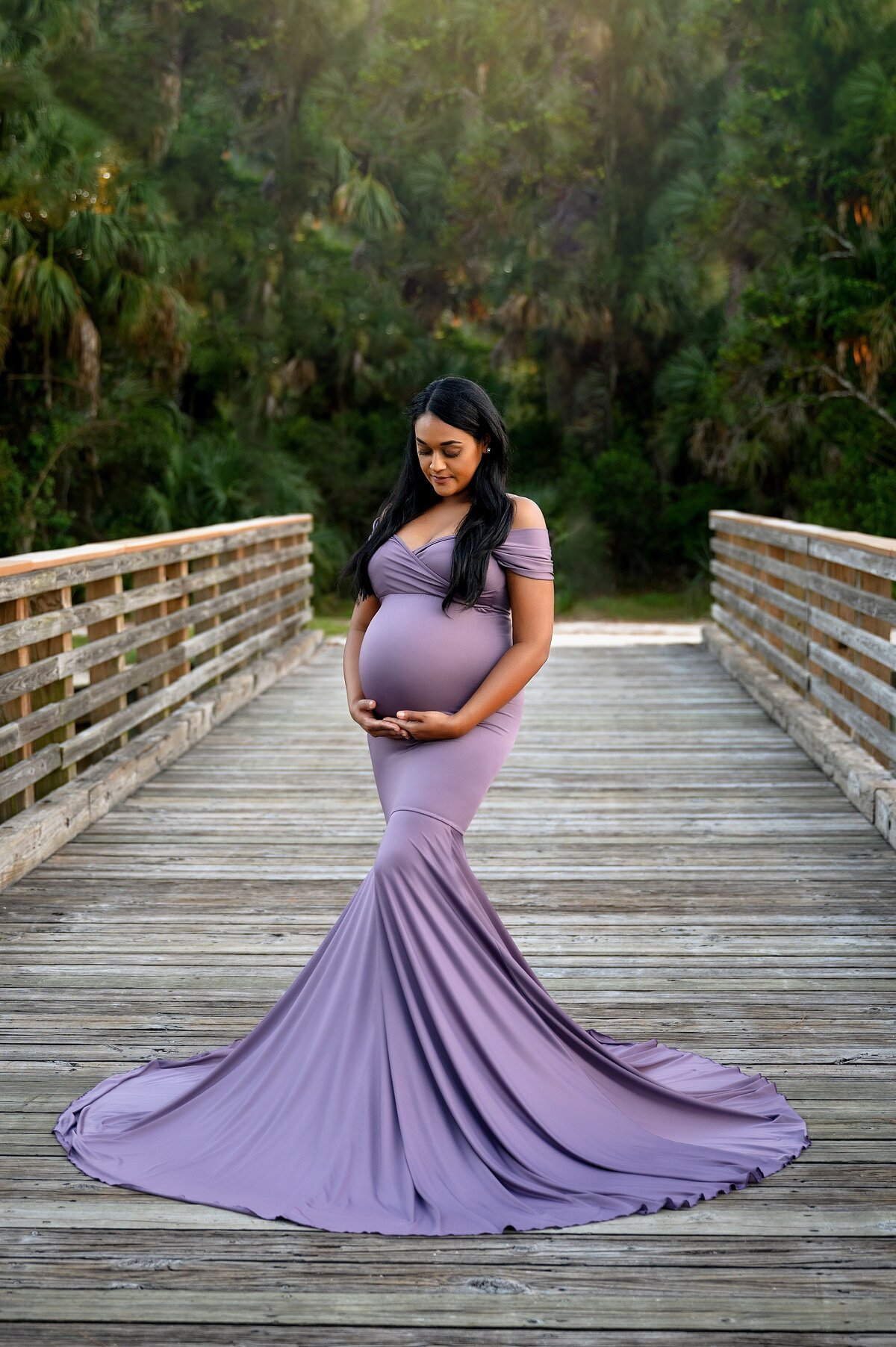 Pregnant model poses on a bridge during sunset in Jupiter for a photoshoot.