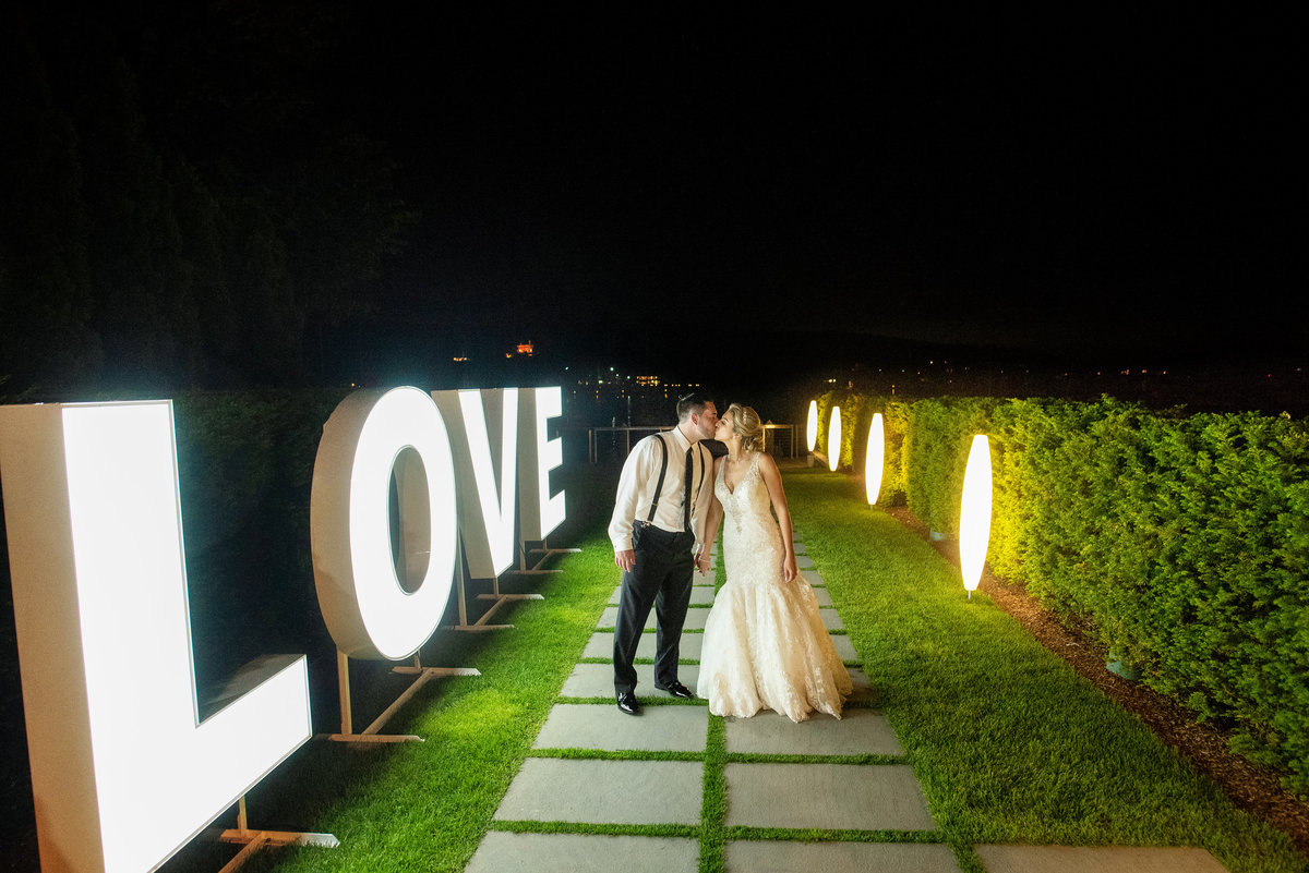 bride and groom kissing at the walkway of Harbor Club at Prime