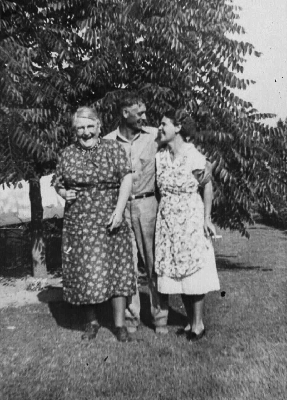 vintage black and white film photograph of a man and woman and mother laughing together