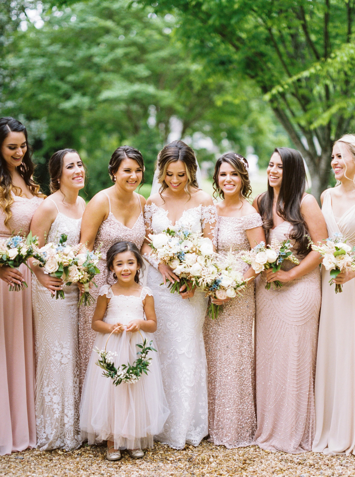 Bridesmaids in blush and sequin gowns, flower girl with floral hoop