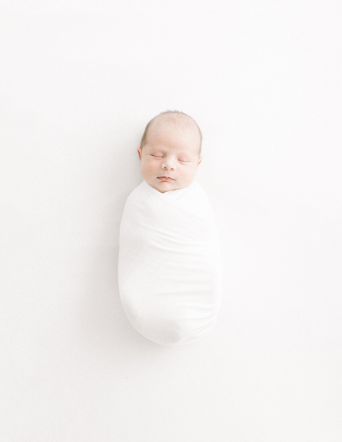 A photo of a newborn baby wrapped and laying down. Captured by a Las Vegas Newborn Photographer