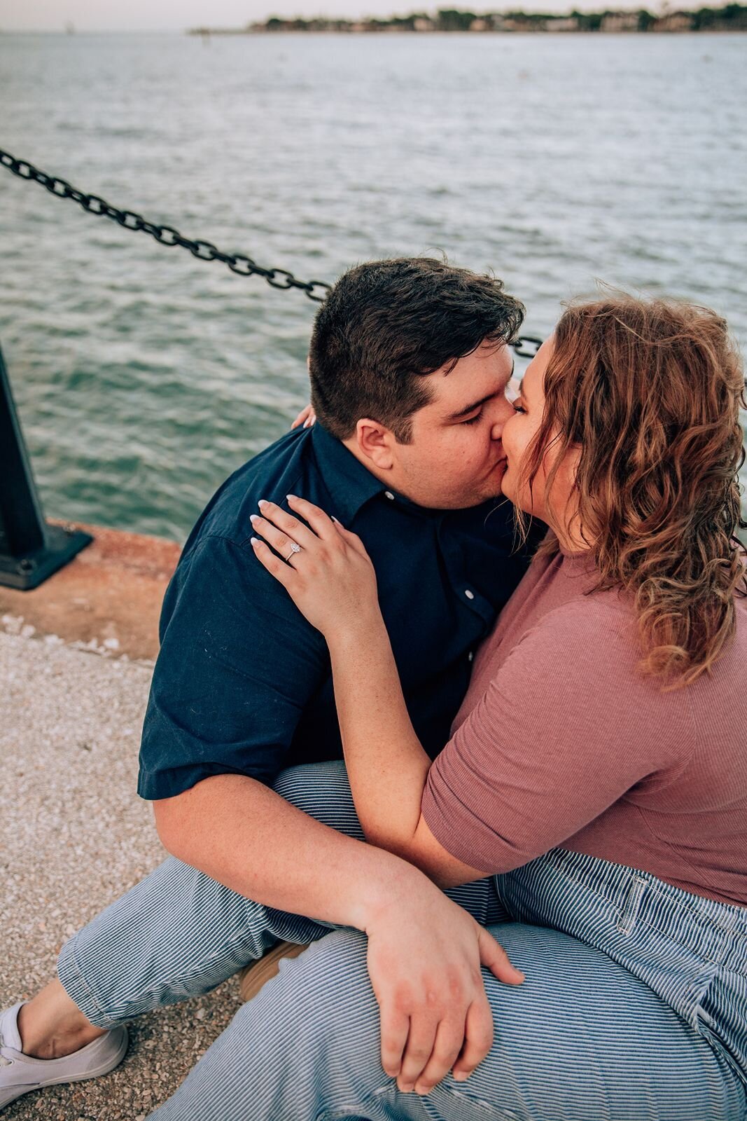 couple in st. augustine florida kissing for engagement photo on a dock