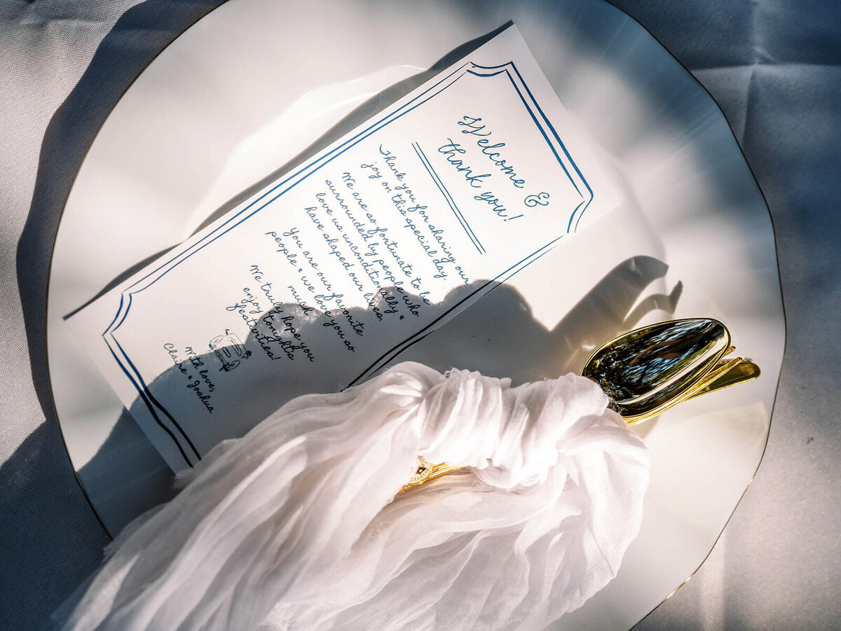 Table setting with plate, silverware and menu.