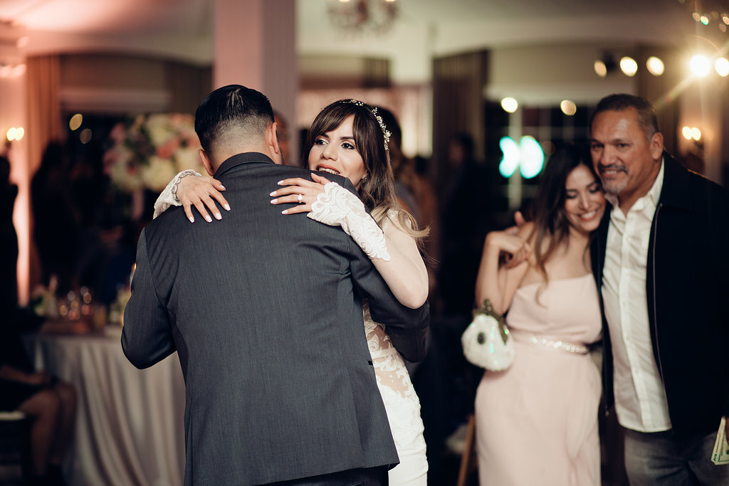 Wedding Photograph Of Bride Hugging A Man In Gray Suit Los Angeles