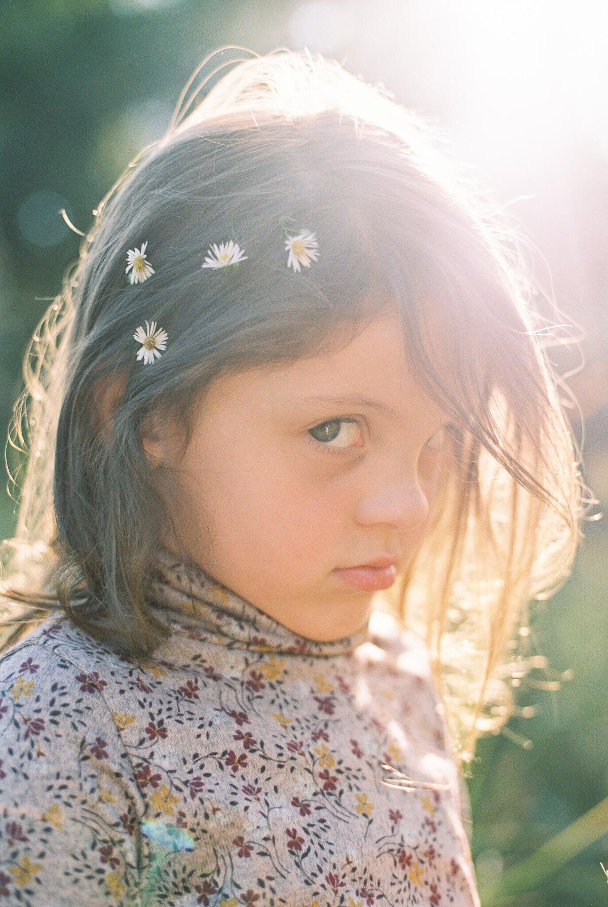 child on film in golden light with flowers in hair