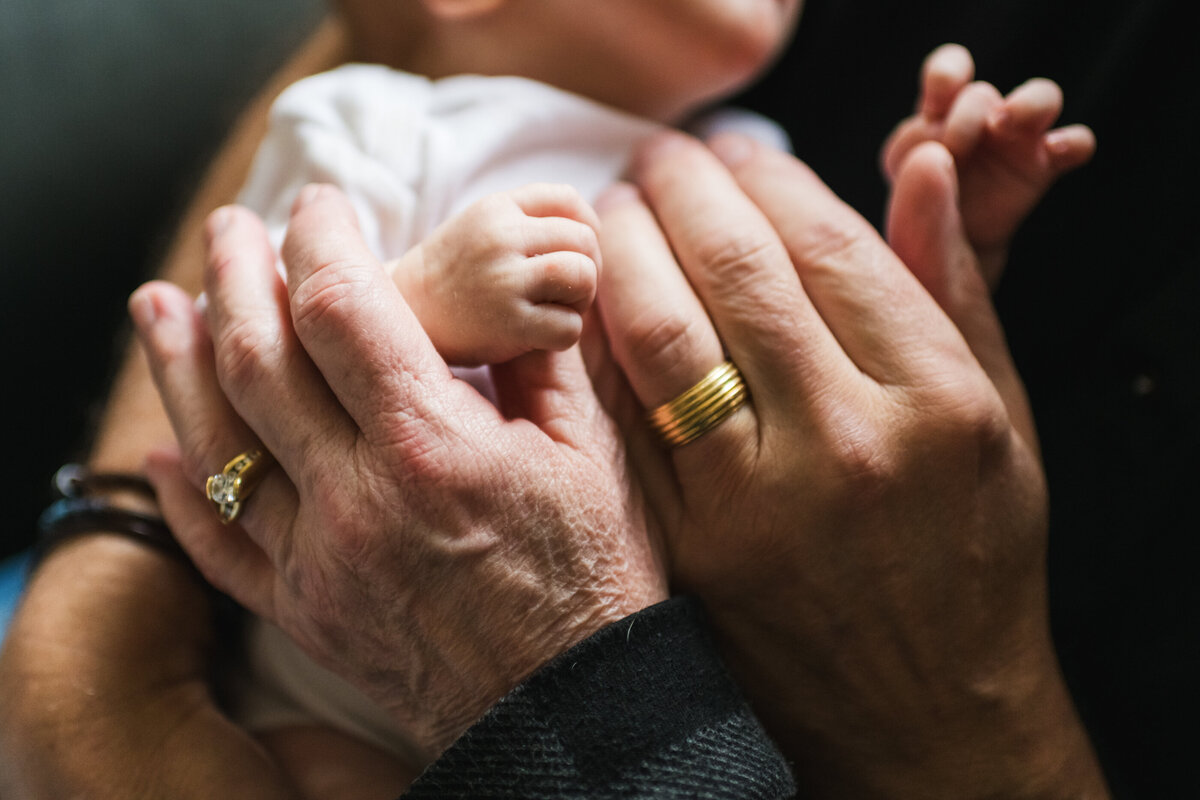 grandparents holding grandchild hands