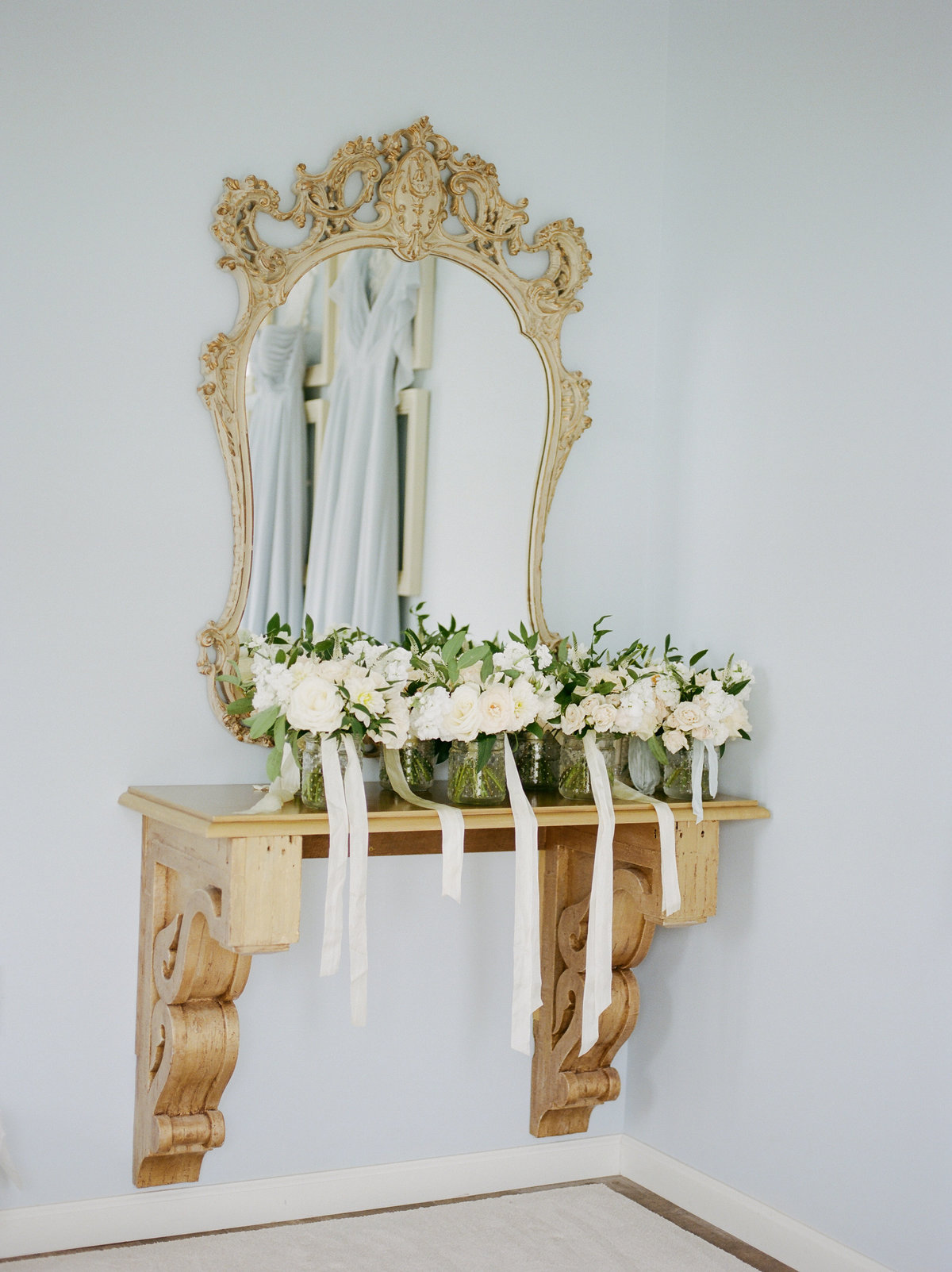 gold mirror with white bridal bouquets
