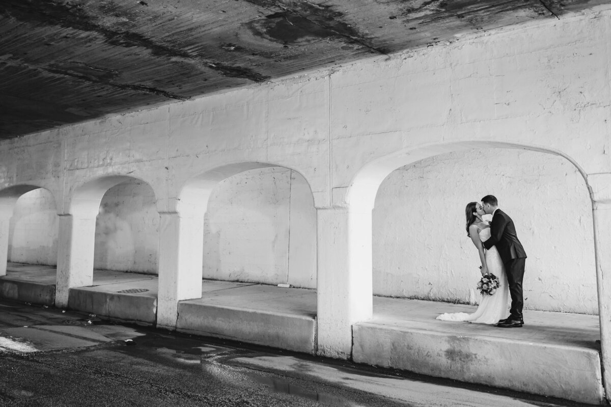 Bride and groom kiss underneath a bridge in Pilsen Chicago, Illinois