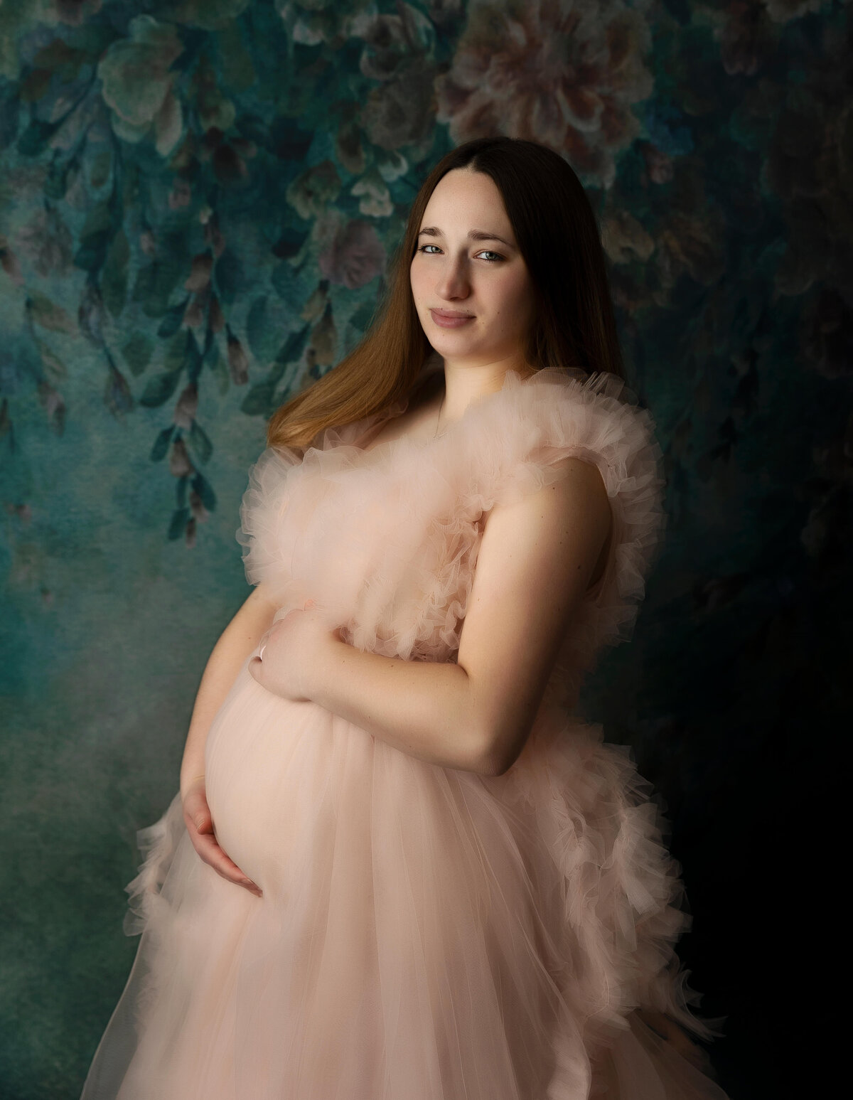 Maternity photo of a girl in a pink dress in and Erie Pa studio