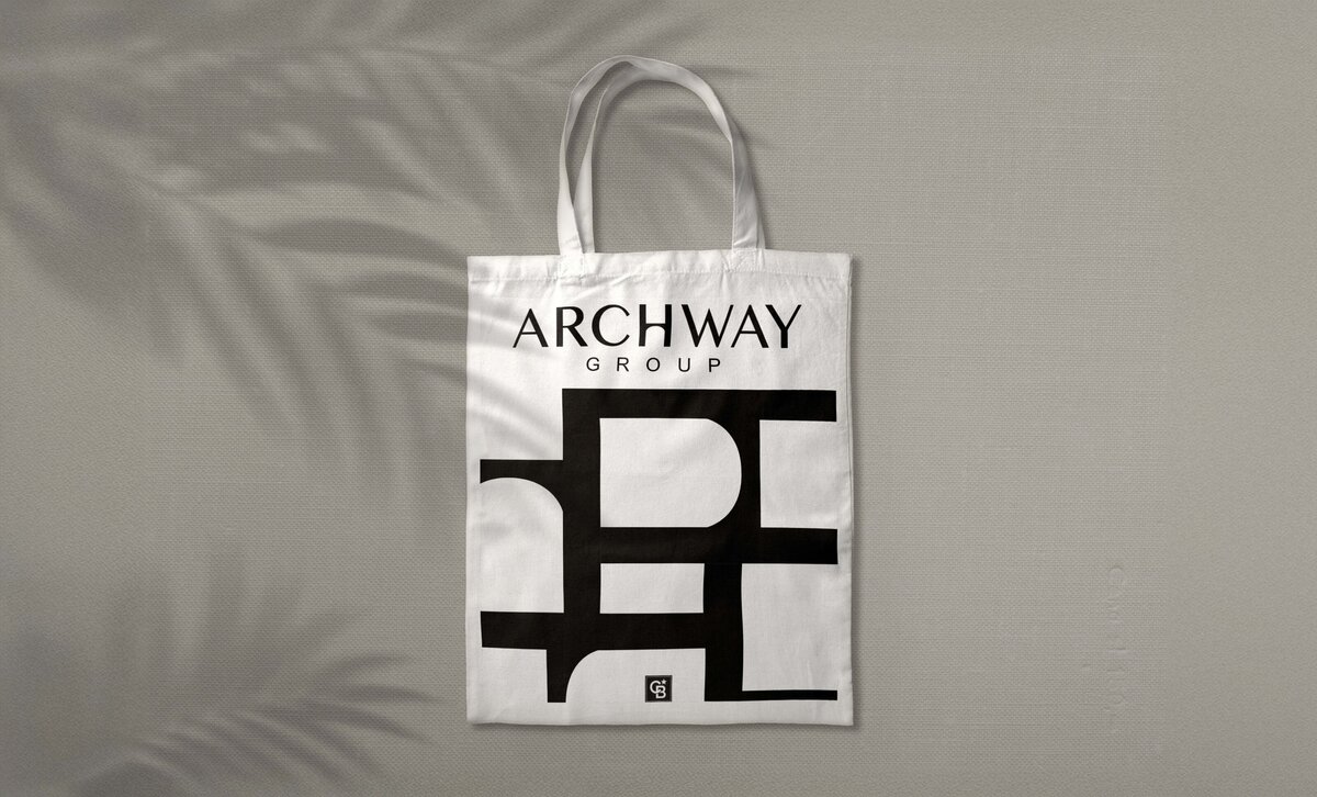 White branded tote bag featuring Archway Group’s bold graphic logo pattern.