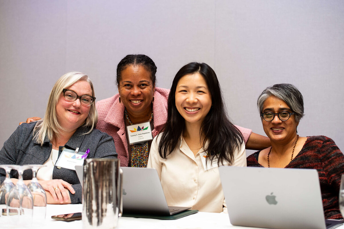 Ottawa event photos showing a team of 4 women smiling together during a corporate conference.  Captured by JEMMAN Photography COMMERCIAL
