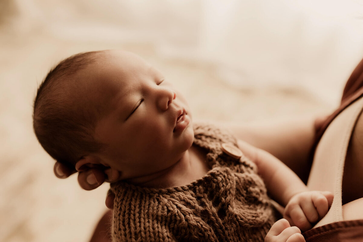 Sleeping newborn boy with window light in the background.