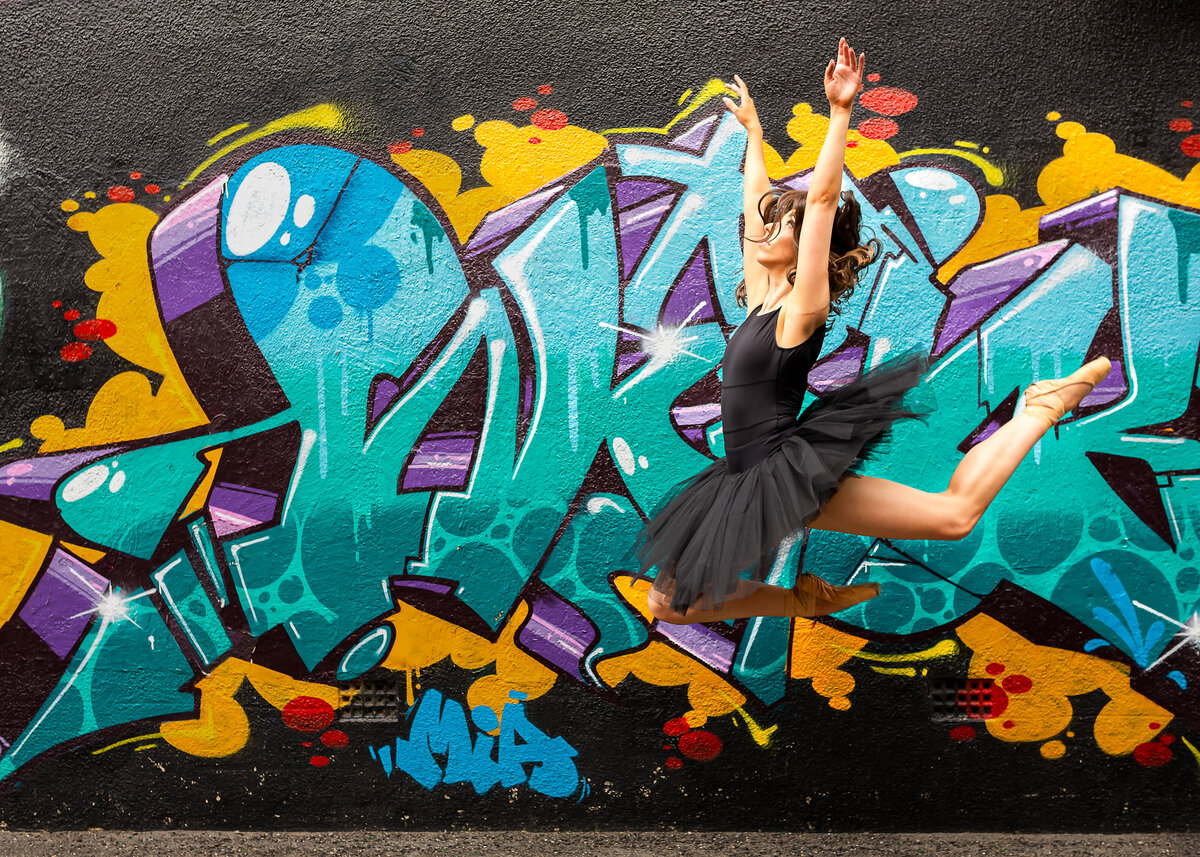 Ballerina jumping in front of graffiti wall Canberra