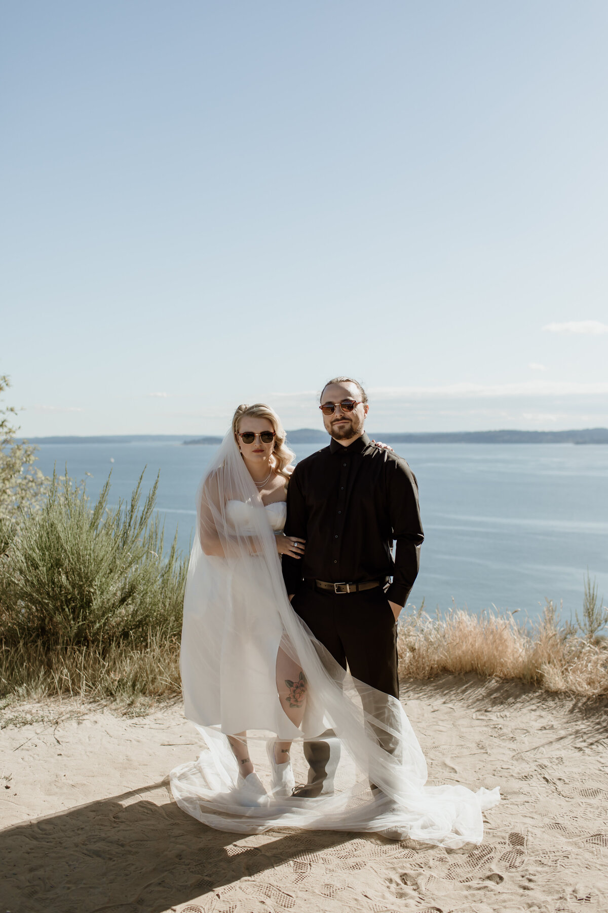 A cool wedding portrait of a bride and groom on the bluffs at Discovery Park in Seattle.   Captured by Fort Worth Wedding Photographer, Megan Christine Studio