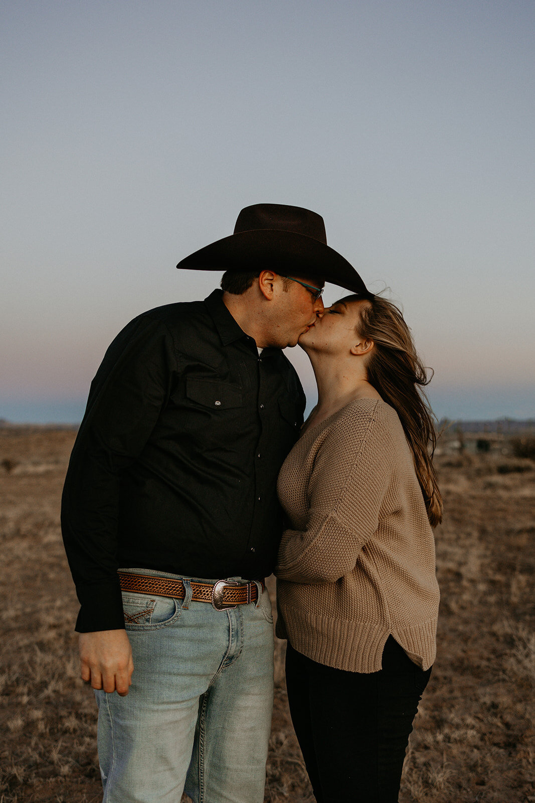 engaged couple kissing in the desert