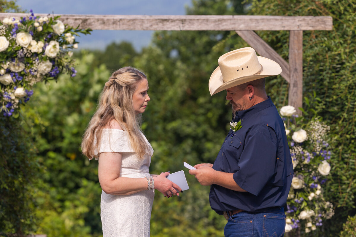bride and groom saying vows with mountain views and florals