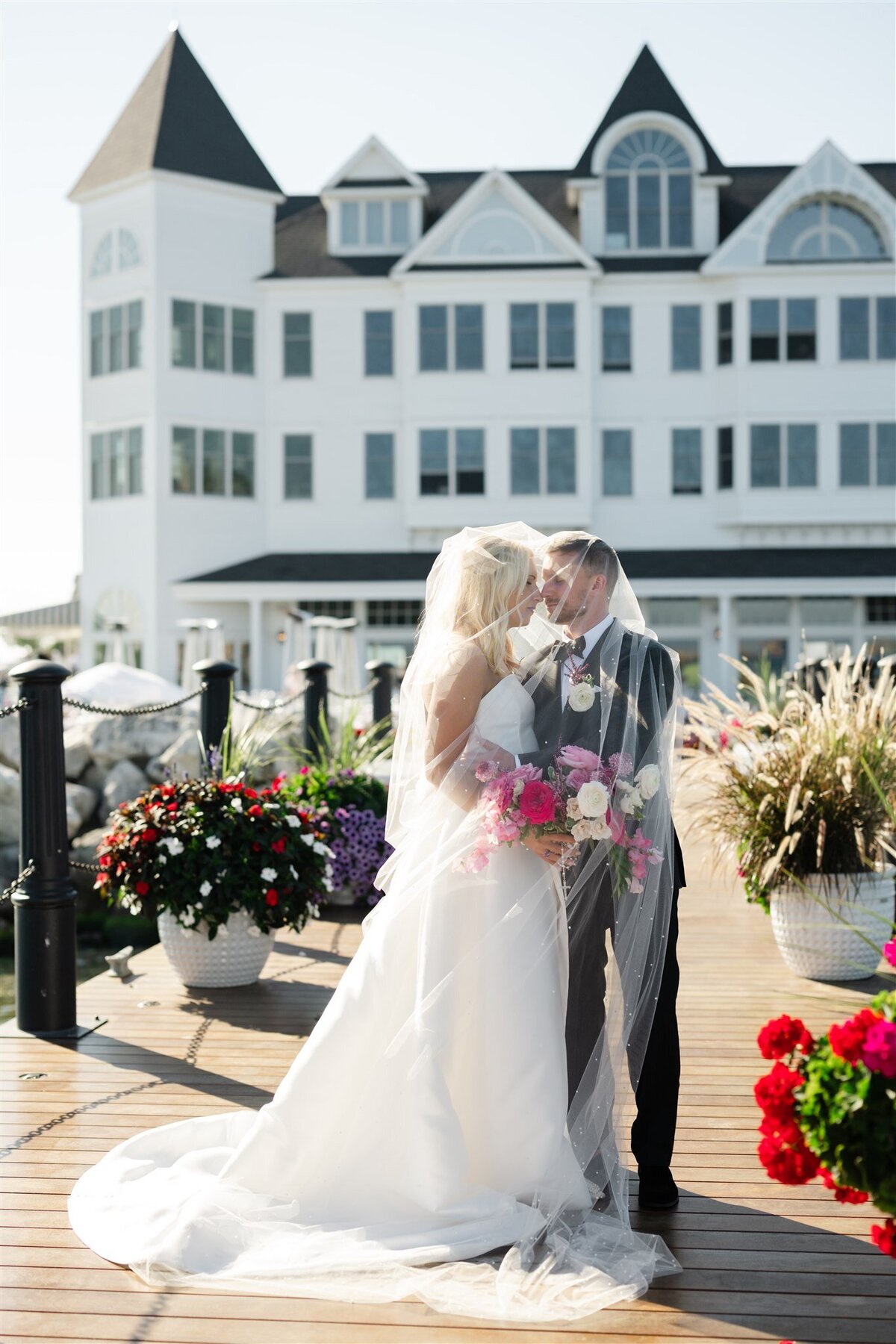Bride and Groom embracing underneath the veil on the dock of Hotel Iroquois on Mackinac Island