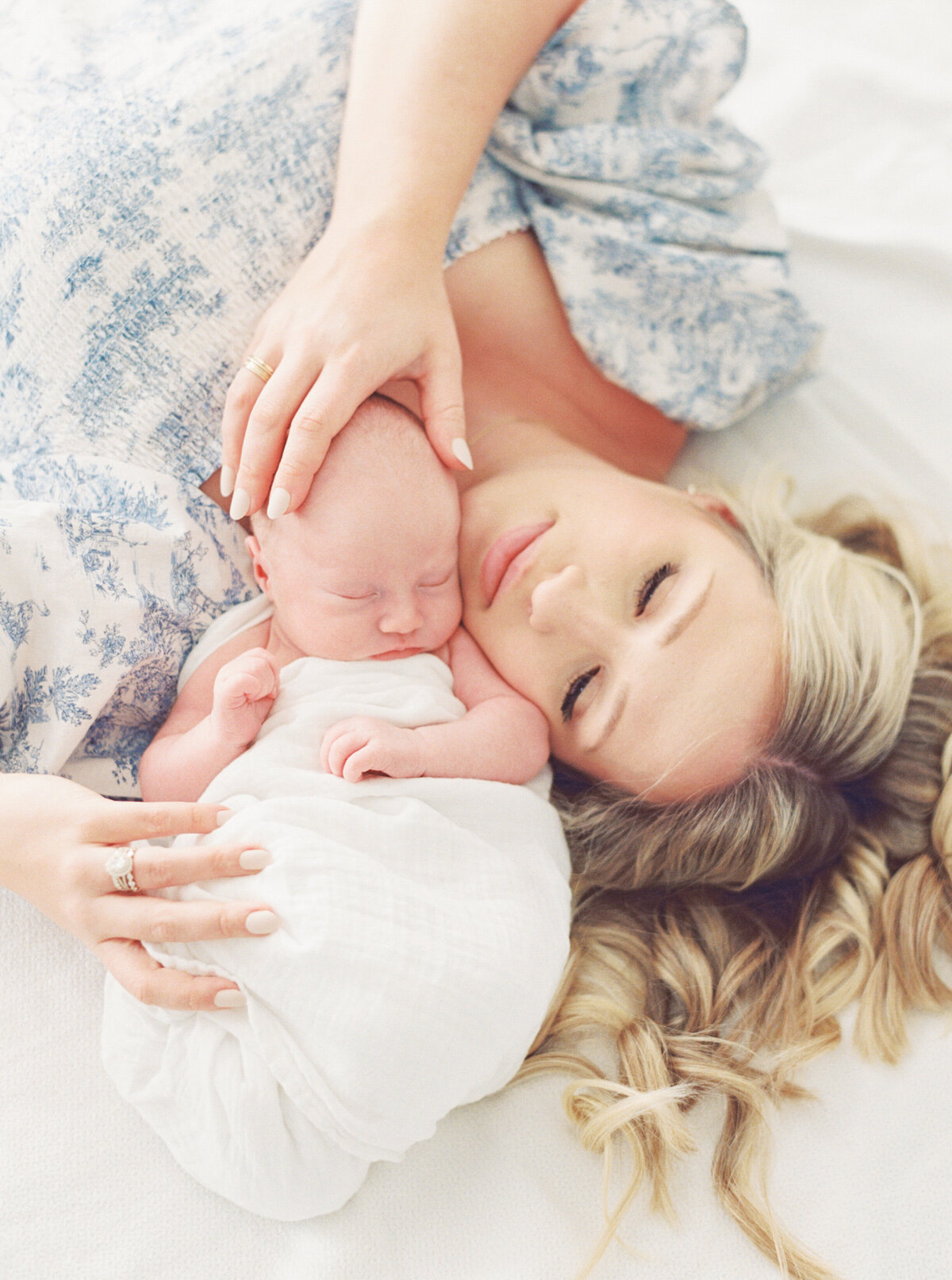 Mom lays with her baby tucked in closely during a newborn session. Image by Raleigh newborn photographer A.J. Dunlap Photography.