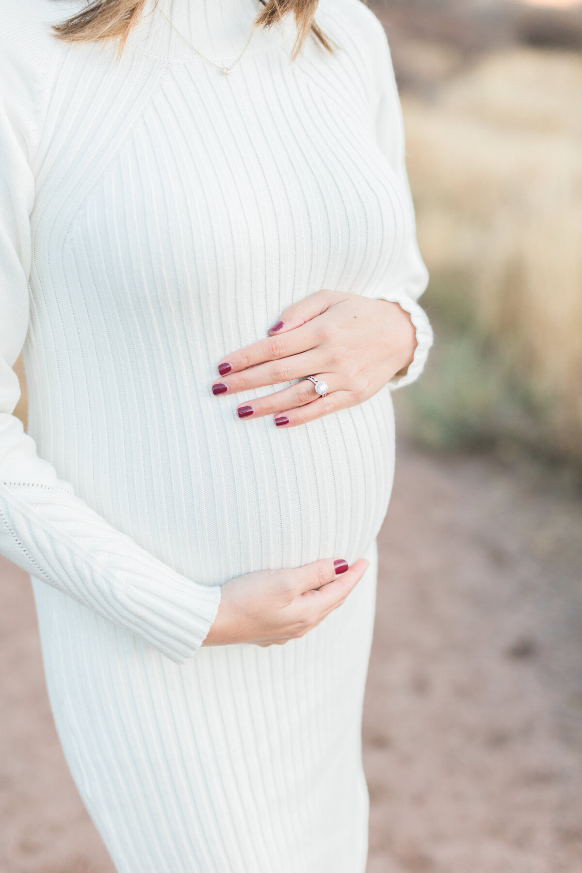 A pregnant mom holding her belly at her Denver maternity session