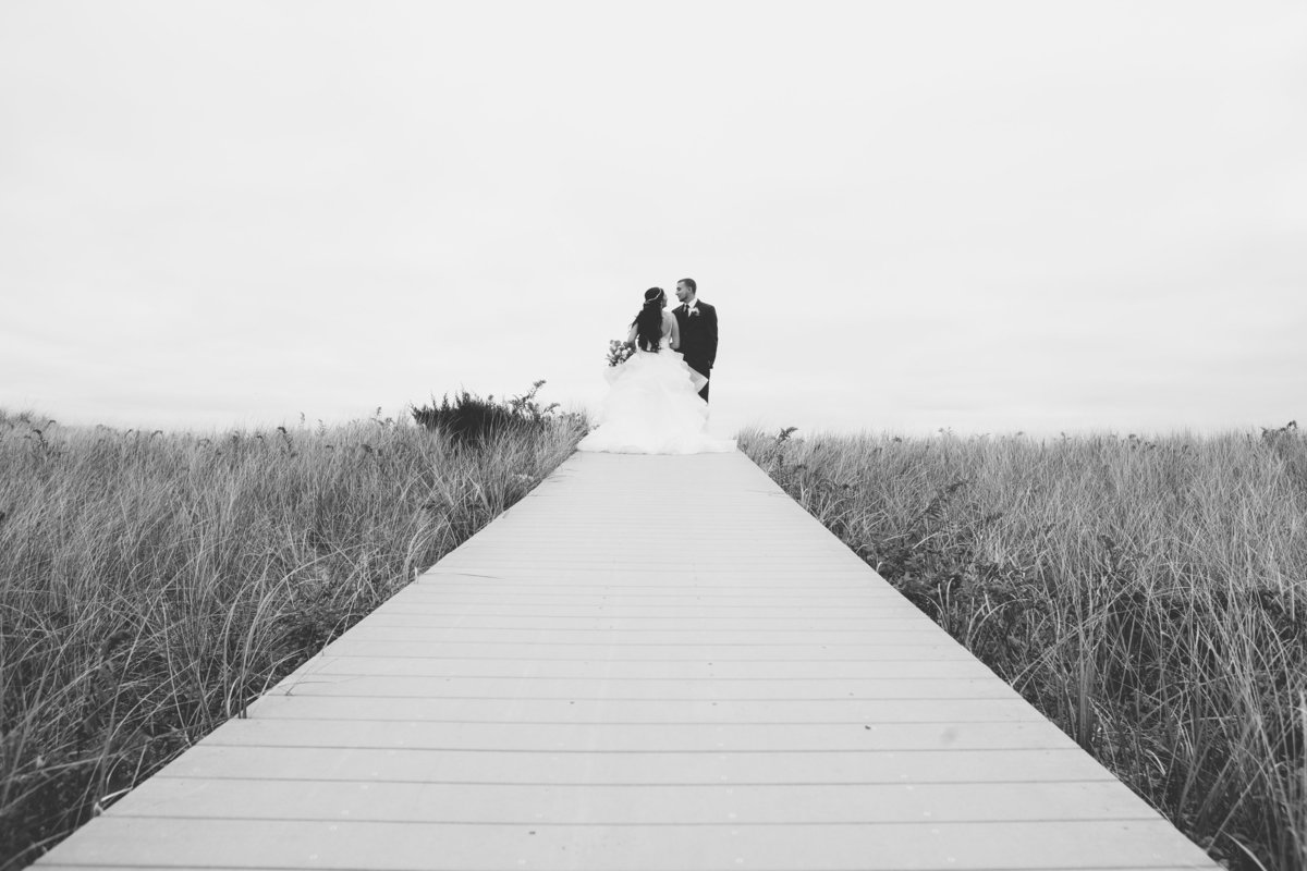 bride and groom black and white photo on boardwalk at Oceanbleu Westhampton