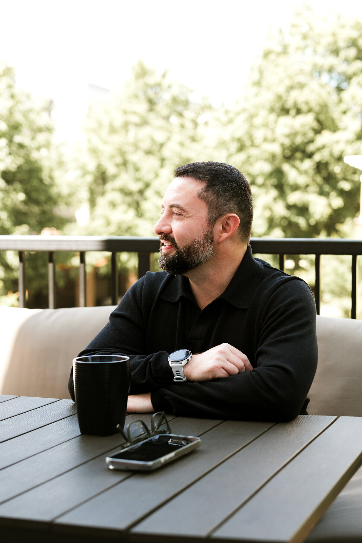 Lifestyle dating profile image of a man enjoying coffee outdoors on a Minneapolis patio, great for showing a casual, relaxed side on dating apps.